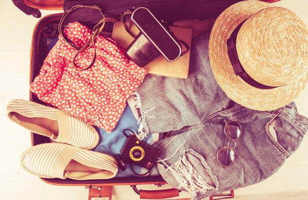 retro bag for summer vocation with photo camera, book and wicker hat. High quality photo - Photo, Image