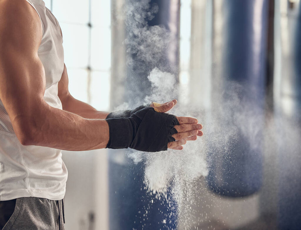 Mma fighter prepare for boxing routine. Combat using chalk to prepare for training workout. Boxer getting ready with dust for combat workout. Athlete using dust on their hands cropped in the gym. - Fotoğraf, Görsel