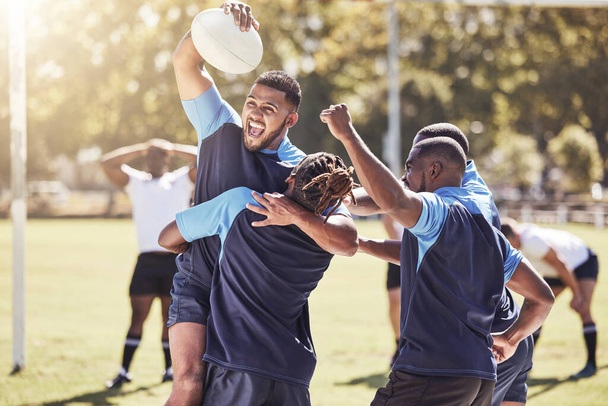 Diverse rugby teammates celebrating scoring a try or winning a match outside on a sports field. Rugby players cheering during a match after making a score. Teamwork ensures success and victory. - Zdjęcie, obraz