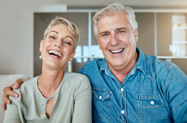 Una felice coppia matura in pensione rilassata che parla e ride insieme in salotto. Sorridente caucasico coppia legame sul divano a casa. - Foto, immagini