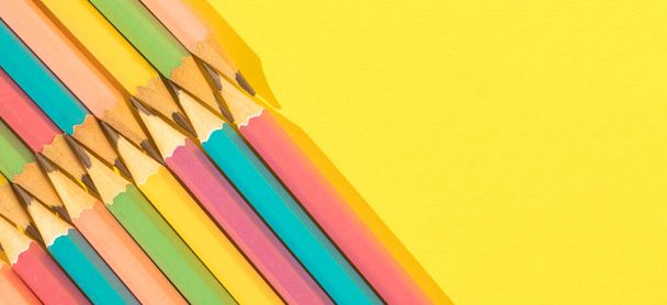 Colored wooden pencils on yellow background. Top view with copy space. Flat lay. Back to school concept. - Фото, зображення