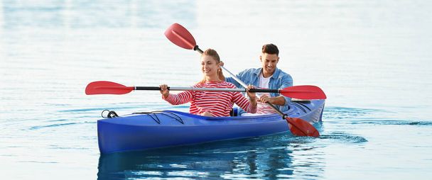 Pareja joven haciendo kayak en el río en el día de verano - Foto, Imagen