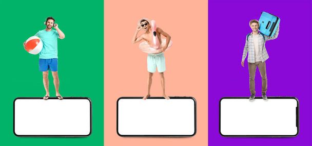 Set of men with luggage, beach accessories and big mobile phones with blank screens on colorful background - Fotoğraf, Görsel