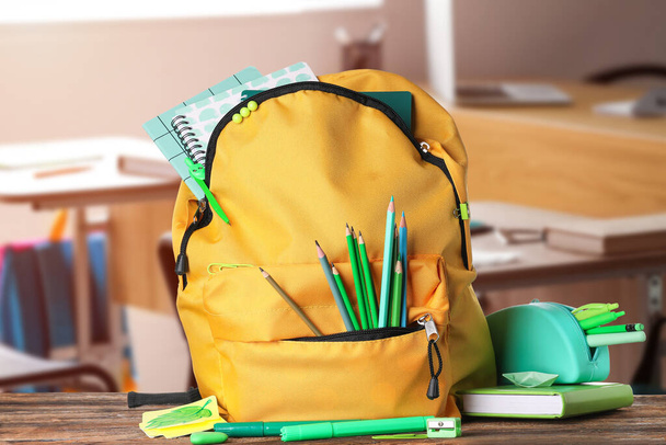 Шкільний рюкзак і канцелярські товари на столі в класі
 - Фото, зображення