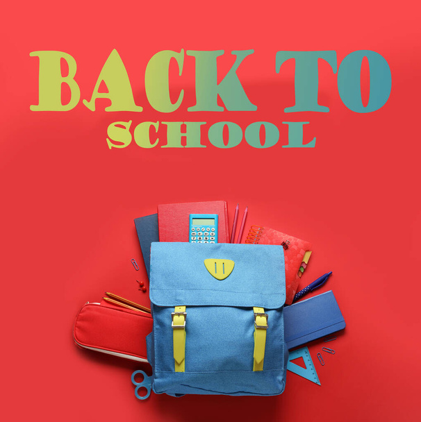 Backpack with stationery and text BACK TO SCHOOL on red background - 写真・画像