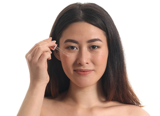 Mladá asijská žena s kosmetické sérum izolované na bílém - Fotografie, Obrázek