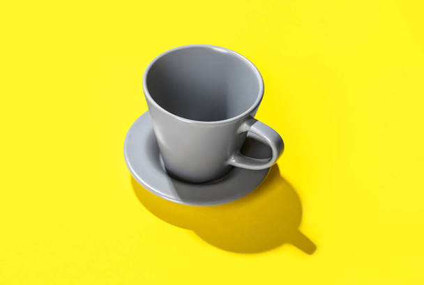 Cup with saucer on yellow background - Zdjęcie, obraz