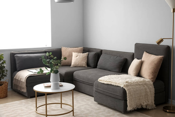 Interiér moderního obývacího pokoje s černou pohovkou a stolem - Fotografie, Obrázek