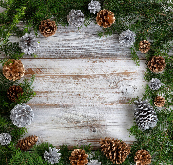 Real fir wreath with gold and silver pine cone ornaments on white rustic wood for the Christmas or New Year holiday concept   - Fotografie, Obrázek