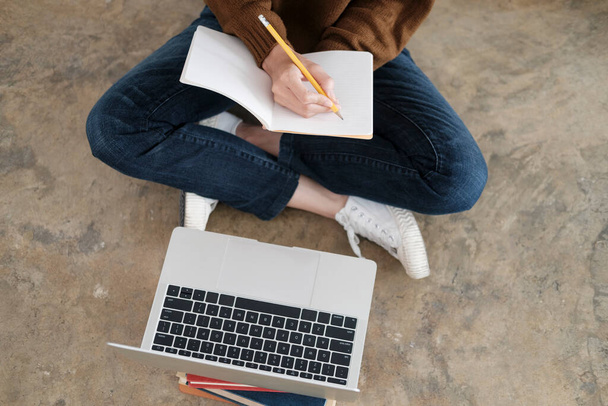 Nuoret naiset opiskelevat kotona. Hän käyttää kannettavaa tietokonetta ja oppimista verkossa. - Valokuva, kuva