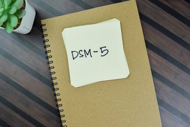 Concept de DSM-5 écrire sur des notes collantes isolées sur Table en bois. - Photo, image