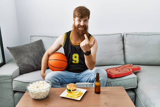Caucasian man with long beard holding basketball ball cheering tv game beckoning come here gesture with hand inviting welcoming happy and smiling  - Photo, image