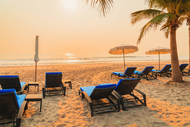 umbrella chair beach with palm tree and sea beach at sunrise times - vacation and holiday concept - Fotó, kép