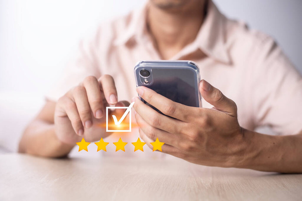 Satisfaction and customer service survey concept, business people using  smartphone. to answer the questionnaire And the satisfaction rating, the satisfaction rating with the icon 5 stars. - Foto, Bild