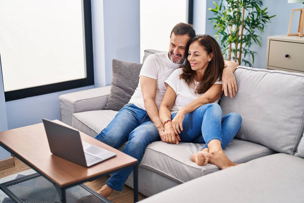 Középkorú férfi és nő pár néz filmet ül kanapén otthon - Fotó, kép
