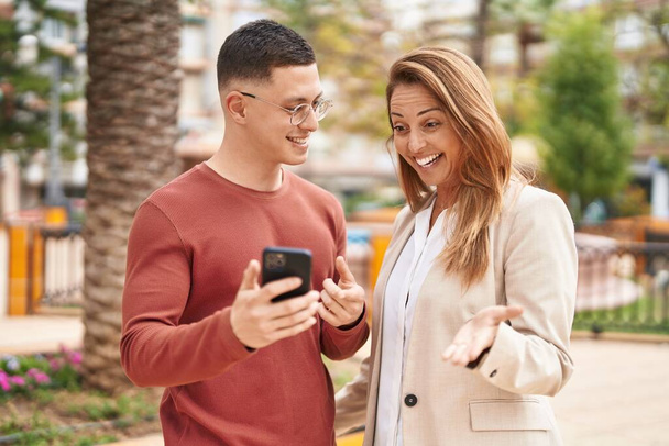 Man and woman mother and son smiling confident using smartphone at park - Φωτογραφία, εικόνα