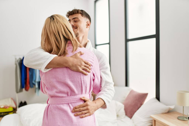 Giovane coppia caucasica sorridente felice e abbracciare in piedi a camera da letto. - Foto, immagini
