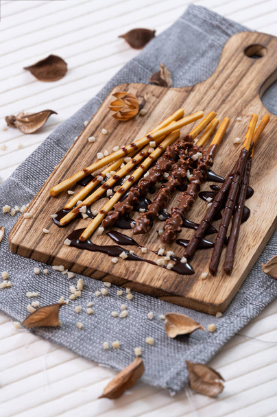 sweet chocolate stick on wooden plate with decorations. - Fotoğraf, Görsel