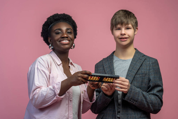 Inclusive education. African american woman and caucasian disabled guy holding abacus smiling at camera standing against light background - Zdjęcie, obraz