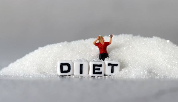 White cube arranged in the word  DIET' with sugar. Business concept with miniature people and sugar. - Foto, immagini