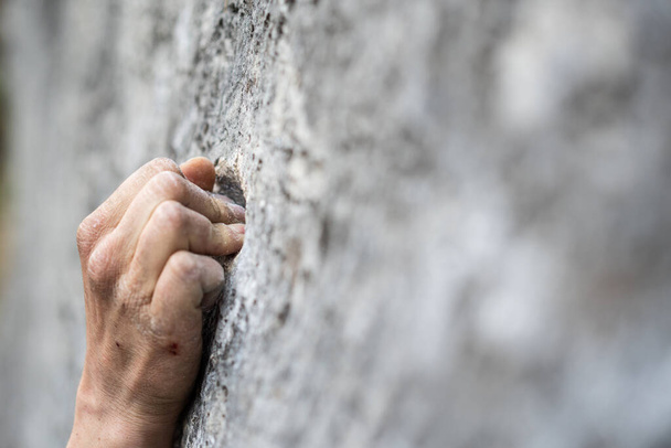 close-up shot van een volwassen man handgreep op een rots, illustratie voor rotsklimmen. - Foto, afbeelding