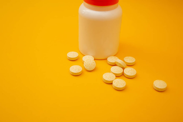 Słoik z tabletkami na żółtym tle - Zdjęcie, obraz