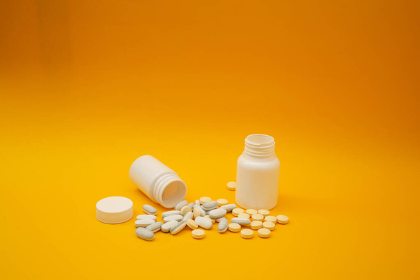 Λευκά χάπια σε κίτρινο φόντο, ιατρικό θέμα - Φωτογραφία, εικόνα
