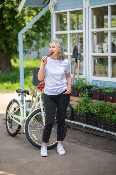 Desert. Smiling woman on a bike enjoying ice-cream - Fotografie, Obrázek
