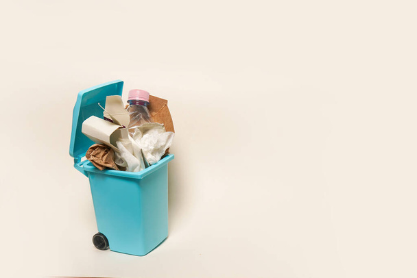 Over full paper trash can on white background with copy space - Фото, изображение