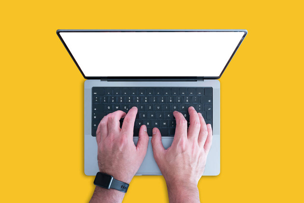vista anterior de la persona que utiliza el ordenador portátil moderno con espacio de copia en la pantalla contra el fondo naranja - Foto, Imagen