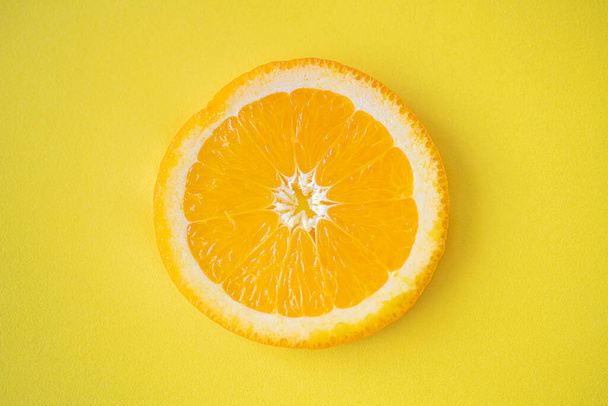 fresh orange slices on a yellow background. - Photo, image