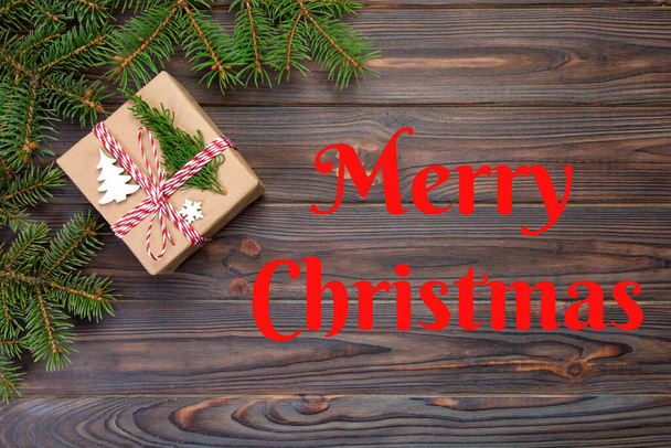 Merry Christmas text. Christmas Background Christmas gift with fir branches on wooden white background with copy space Flat lay, top view. - Φωτογραφία, εικόνα