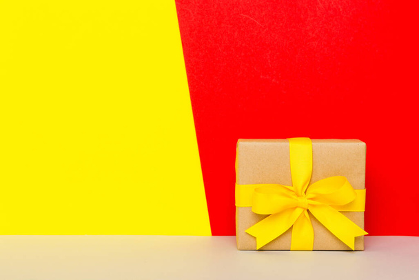 holiday paper present tied yellow ribbon bow top view with copy space. Flat lay holiday background. Birthday or christmas present. Christmas gift box concept with copy space. - Foto, afbeelding