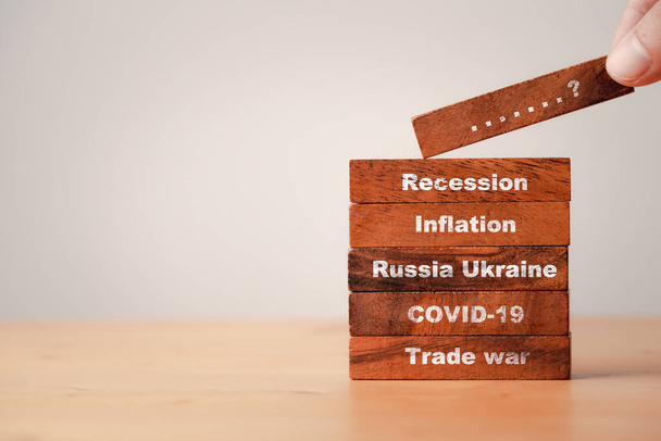 Hand stacking wooden block which print screen scenario since trade war COVID-19 Russia Ukraine Inflation and Economic recession concept. - Photo, Image