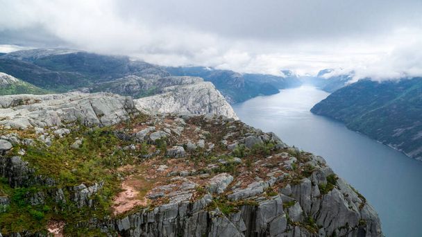 Lysefjord between high mountains on a cloudy day passing Preikestollen - 写真・画像