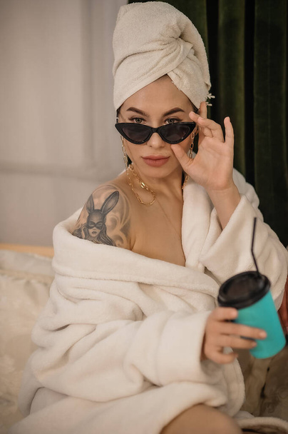 beautiful young woman with towel on her face and bathrobe in the bathroom - Valokuva, kuva