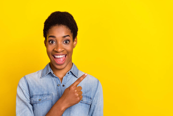Portrait of excited funny person direct finger empty space offer sale discount isolated on yellow color background. - Zdjęcie, obraz