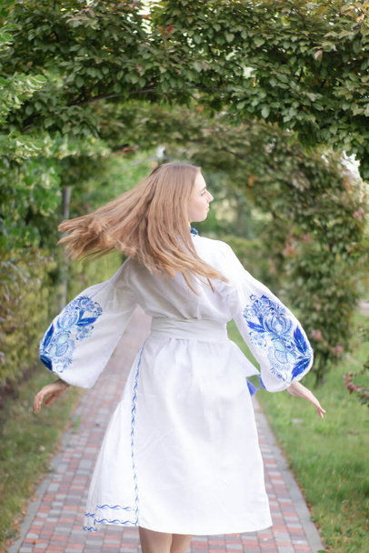 Retrato de mujer joven con camisa bordada tradicional nacional azul. chica bonita al aire libre vestida con ropa patriótica. - Foto, Imagen