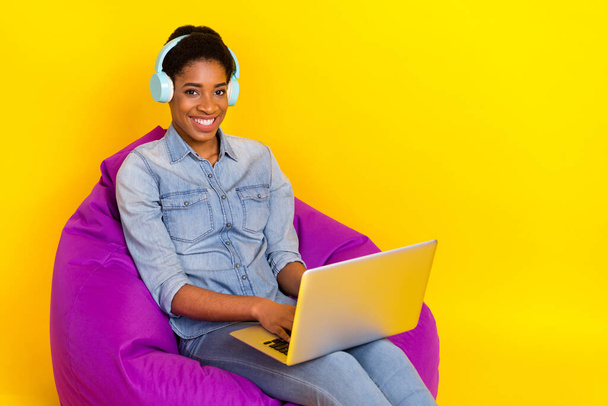 Portrait of positive friendly person sit violet bag use netbook write email isolated on yellow color background. - Φωτογραφία, εικόνα
