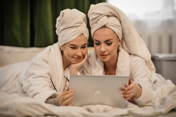 belas mulheres jovens com sua filha em roupão de banho e toalha na cama no quarto - Foto, Imagem