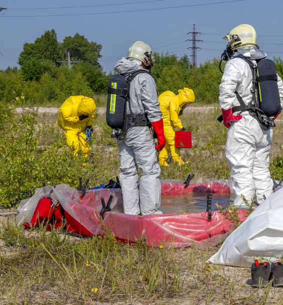 Hazmat teamleden hebben het dragen van beschermende pakken om hen te beschermen tegen gevaarlijke materialen - Foto, afbeelding