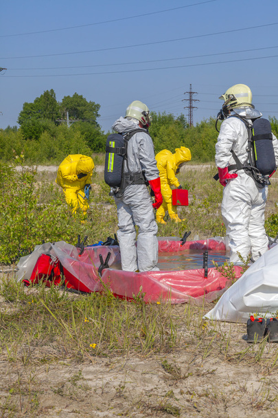 Los miembros del equipo de materiales peligrosos han estado usando trajes de protección para protegerlos de materiales peligrosos
 - Foto, imagen