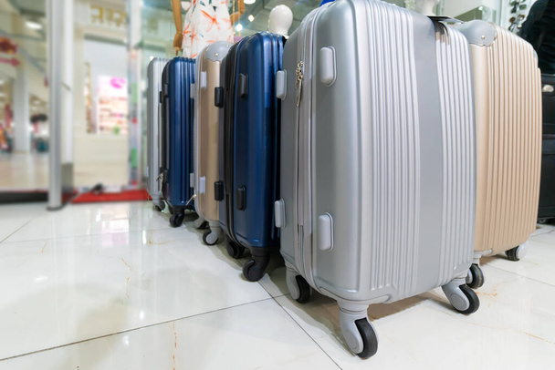 Close-up of gray, blue, beige suitcases in the store. Luggage bags in the store. Sale of suitcases for trips - Fotografie, Obrázek