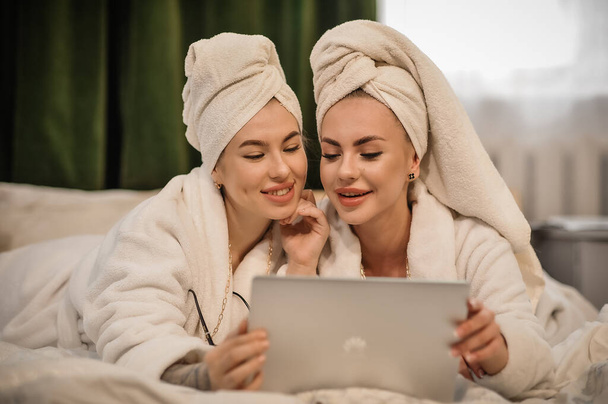 beautiful young women with her daughter in bathrobe and towel in bathrobes in spa center - Фото, изображение