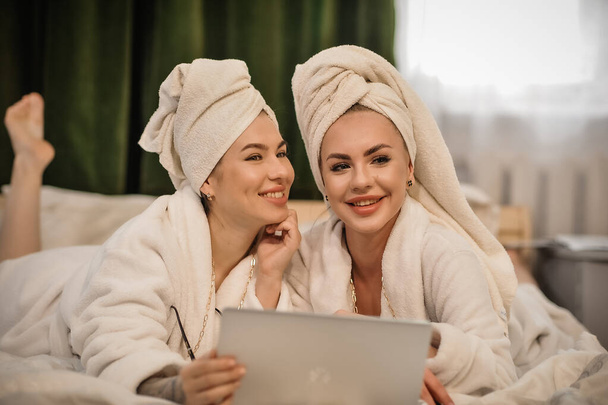 kauniit nuoret naiset pyyhkeellä kylpytakissa ja pyyhkeillä kylpylässä - Valokuva, kuva