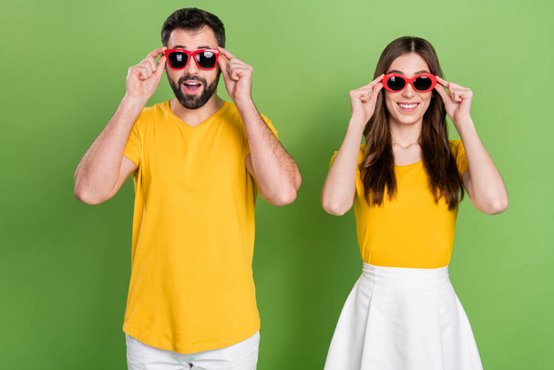 Portrait of cheerful positive people toothy smile hands touch glasses isolated on green color background. - Foto, Bild