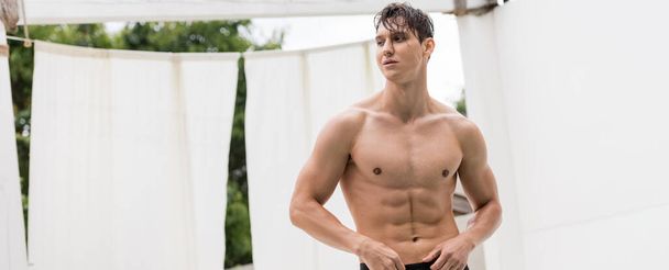 man with wet muscular torso looking away outdoors, banner - Foto, immagini