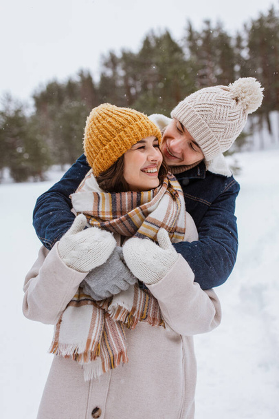 people, love and leisure concept - happy smiling couple hugging in winter park - 写真・画像