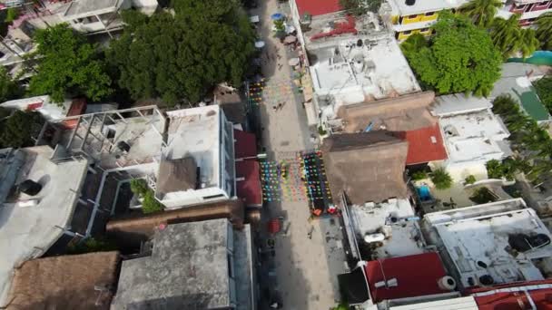 Birds eye perspective above a commercial street with colorful bunting and restaurant outdoor dining areas in the center of Playa del Carmen, Mexico. - Filmati, video