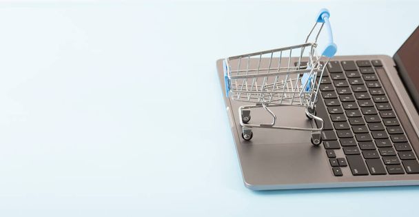İnternetten alışveriş konsepti. Alışveriş arabası, küçük kutular, masanın üstünde dizüstü bilgisayar. Yüksek kalite fotoğraf - Fotoğraf, Görsel
